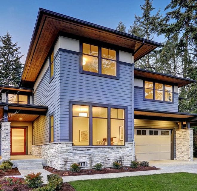 A blue house with a driveway and lawn.